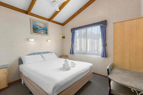 Anchor Belle Holiday Park في كاوز: غرفة نوم بسرير كبير ونافذة