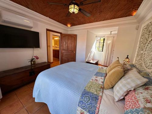 a bedroom with a bed and a flat screen tv at Casa Mona Lisa, a short, level walk to the cathedral in San Miguel de Allende