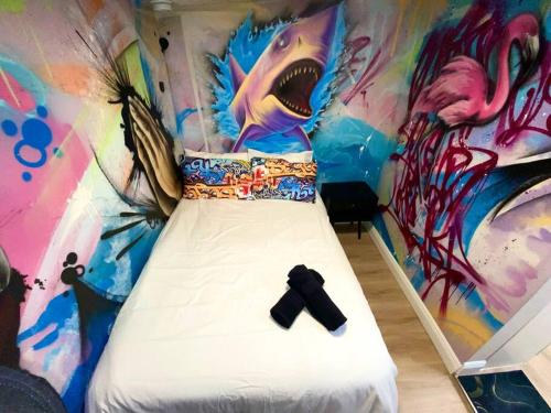 a bed in a room with a wall covered in graffiti at Cozy & Colorful Miami Art Canvas w/HotTub & Murals in Miami