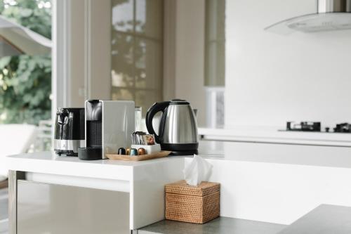 a kitchen counter with a coffee maker and a coffee pot at Kula Kara Villas Uluwatu in Uluwatu