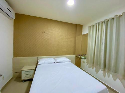 sypialnia z białym łóżkiem i oknem w obiekcie VG Fun Fortaleza - Apartamento de Temporada na Praia do Futuro w mieście Fortaleza
