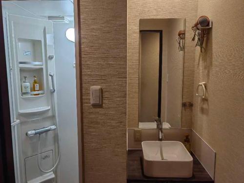 uma casa de banho com um lavatório e um espelho em Mini Inn Kyoto 京都 - 外国人向け - 日本人予約不可 em Quioto