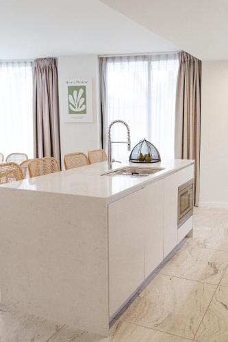a kitchen with a white island in a room at Breeze Mooloolaba, Ascend Hotel Collection in Mooloolaba