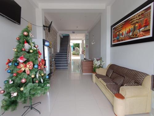 a christmas tree in a living room with a couch at Hotel Inambari Golden in Chiforongo