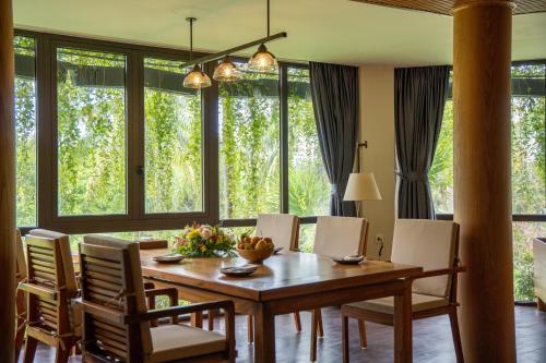 a dining room with a wooden table and chairs at Pax Ana Doc Let Resort & Spa in Ninh Hòa