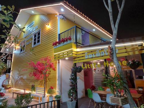 una casa amarilla con una mesa delante en ลิตเติ้ลโฮม ที่พักเพชรบุรี, en Phetchaburi