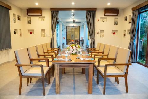 a dining room with a long table and chairs at Pax Ana Doc Let Resort & Spa in Ninh Hòa