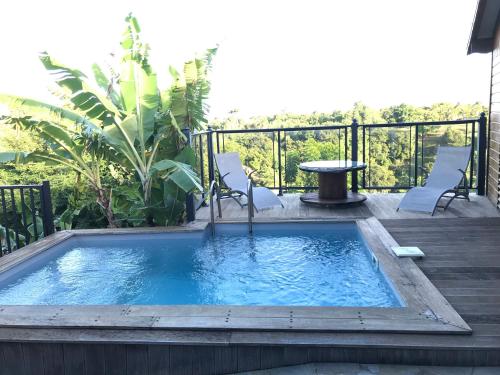 a small pool with chairs and a table on a deck at Villa HAVRE DE PAIX in Le Gosier