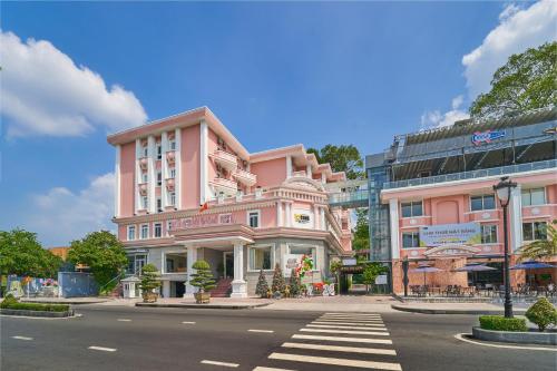 un edificio rosa sul lato di una strada di Bcons Riverside Hotel Binh Duong a Thu Dau Mot