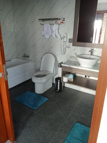a bathroom with a tub and a toilet and a sink at Mesari Villa in Keramas