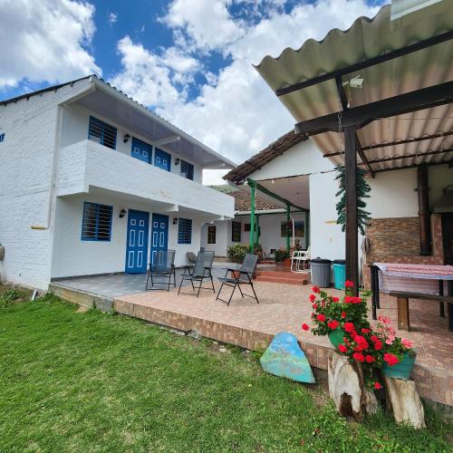 a white house with blue doors and a patio at Posada Turistica Nakku in Silvia