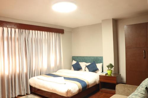 ein Hotelzimmer mit einem Bett und einem Fenster in der Unterkunft Apartment Elegant Kathmandu in Kathmandu
