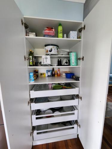 a kitchen pantry with white shelves at OXLEY Mineral Pool & Private Home suburbanSTAY in Brisbane