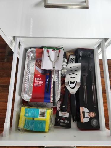 a drawer filled with kitchen utensils and other items at OXLEY Mineral Pool & Private Home suburbanSTAY in Brisbane