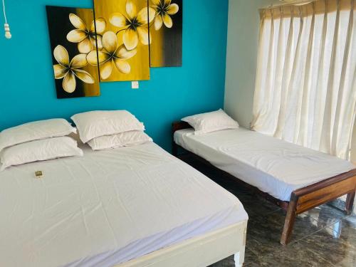 two beds in a room with blue walls at Hotel Ceylon Heritage in Yala