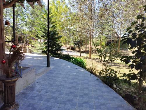 a walkway in a park with trees in the background at The O'clock Farmstay Khaokor in Khao Kho