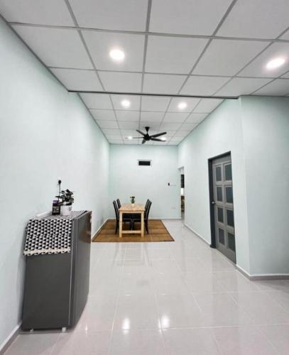 una sala da pranzo con tavolo e ventilatore a soffitto di HOMESTAY UMMI KOTA BHARU a Kota Bharu