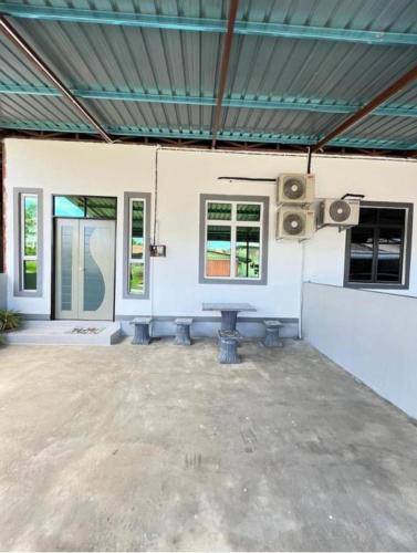 ein leeres Zimmer mit einem Tisch und Lautsprechern in der Unterkunft HOMESTAY UMMI KOTA BHARU in Kota Bharu