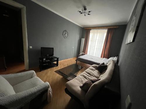 sala de estar con 2 camas y sofá en Sunny Apartment Near Vake Park en Tiflis