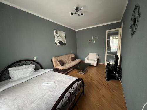 1 dormitorio con 1 cama grande y 1 sofá en Sunny Apartment Near Vake Park en Tiflis