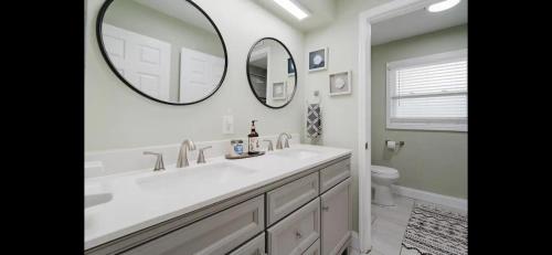 bagno con lavandino e grande specchio di Justins Guest Rooms a Bradenton