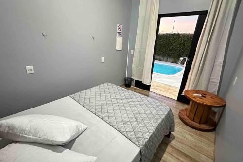 1 dormitorio con 2 camas y puerta a la piscina en Casa com Piscina (Somente para 4 Hóspedes). en Sinop