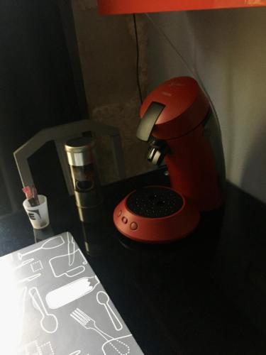un mixeur rouge assis au-dessus d'un bureau dans l'établissement Chambre sur jardin secret - Avignon Centre - Climatisée, à Avignon