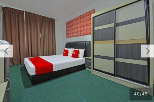 a bedroom with a bed with a red blanket at SYAHIRAH HOTEL in Marang