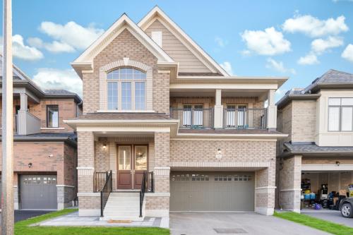 a house with a garage in front of it at Luxury Whitby 4BR, Near Restaurants - Family, Pool Table, Parking! in Whitby
