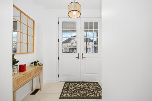 a hallway with white doors and a rug at Luxury Whitby 4BR, Near Restaurants - Family, Pool Table, Parking! in Whitby
