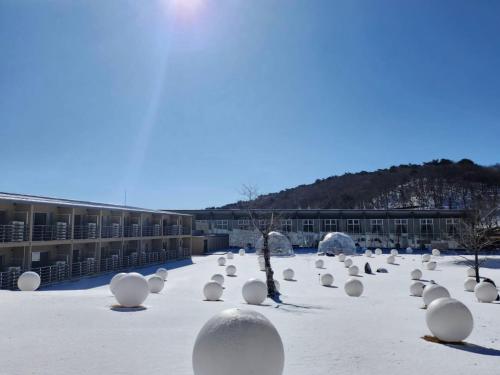 a courtyard covered in snow with white spheres at Mineyama Kogen Hotel Relaxia in Kamikawa