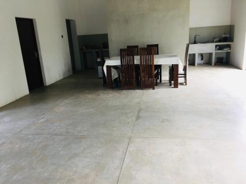 een eetkamer met een witte tafel en stoelen bij Coconut House in Panadura