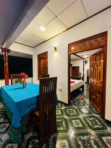 una sala da pranzo con tavolo e una camera da letto di Shanika Guest & Villa a Mirissa