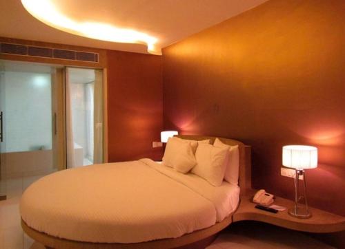 a bedroom with a large bed and two lamps at Cocoon Luxury Business Hotel in Dhanbād