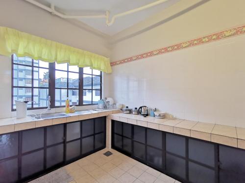 a large kitchen with two sinks and two windows at Prima Villa Apartment Tanah Rata Cameron Highland in Tanah Rata