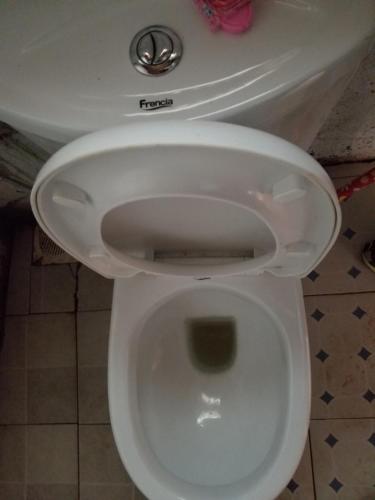 um WC branco com o assento para cima na casa de banho em Rock garden Sipi em Kapchorwa