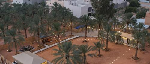 an overhead view of a courtyard with palm trees and lights at منتجع الرتاج الريفي in Buraydah