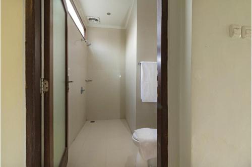 a bathroom with a toilet and a walk in shower at Lumbung Asri Cottage in Mambat