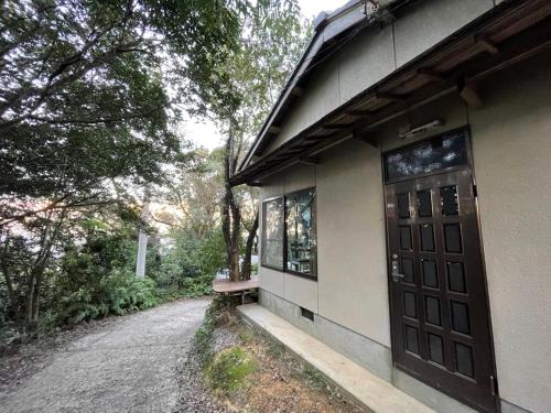 a building with a door and a bench next to a road at Yamamizuki in Shimanto