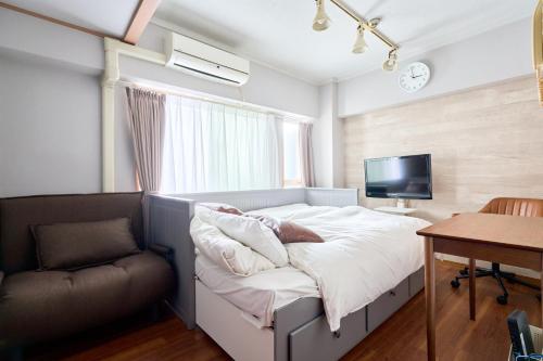 a bedroom with a bed and a chair and a tv at JR高田馬場駅早稲田大学口徒歩5分 Hostel 302 in Tokyo