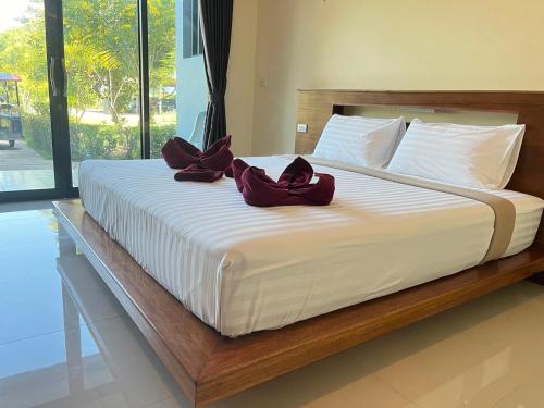 a large bed with two purple bows on it at Dusit Long Beach in Ko Lanta