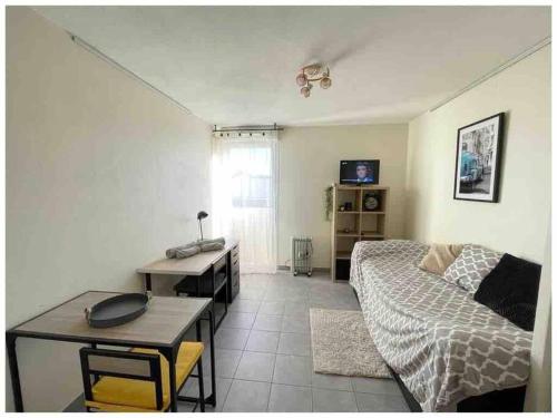 un salon avec un lit et une table dans l'établissement Studio Castelnau le lez proche Montpellier odysseum et tram, à Castelnau-le-Lez