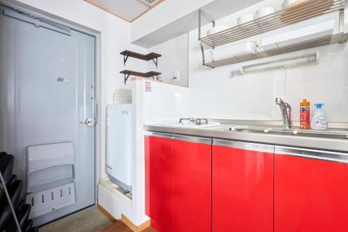 a kitchen with red cabinets and a sink at JR高田馬場駅早稲田大学口徒歩5分 Hostel 302 in Tokyo