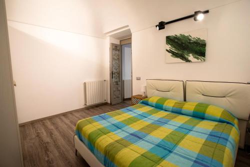 ein Schlafzimmer mit einem Bett mit einer bunten Decke in der Unterkunft Civico 10 in Sanremo