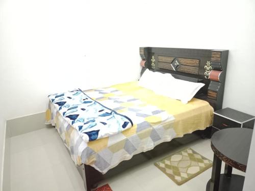 a small bedroom with a bed and a table at Hotel Mallard Rainbow in Bharatpur