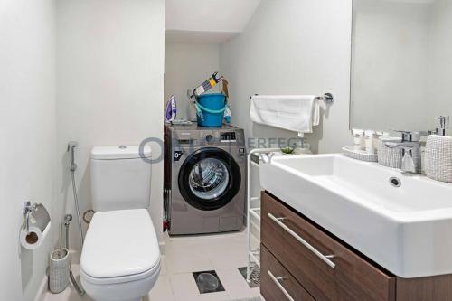 a bathroom with a washing machine and a sink at Spacious 3BR Townhouse in Mimosa, Damac Hills 2 in Dubai