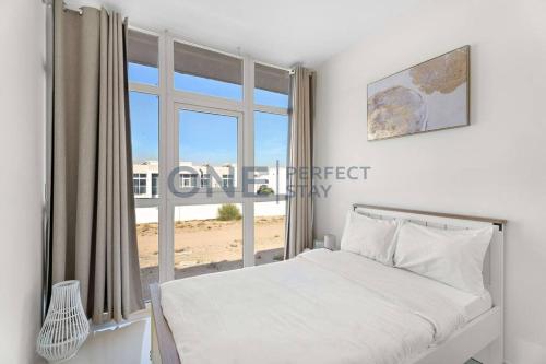 a bedroom with a bed and a large window at Spacious 3BR Townhouse in Mimosa, Damac Hills 2 in Dubai