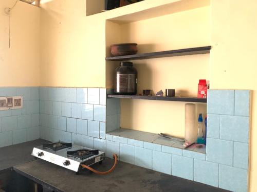 uma cozinha com fogão e prateleiras num quarto em Harbour town holiday home -malpe em Malpe