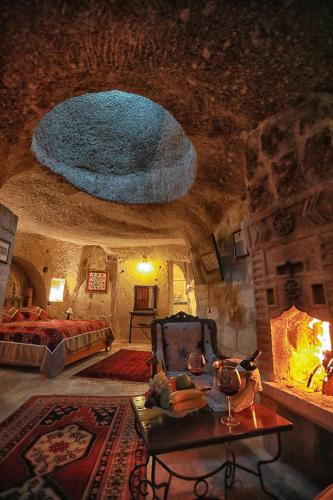 a bedroom with a bed and a table in a room at Traveller's Cave Hotel in Goreme