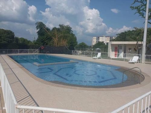 a large swimming pool with two chairs around it at Apartamento en Ricaurte, Arrayanes de Peñaliza in Ricaurte